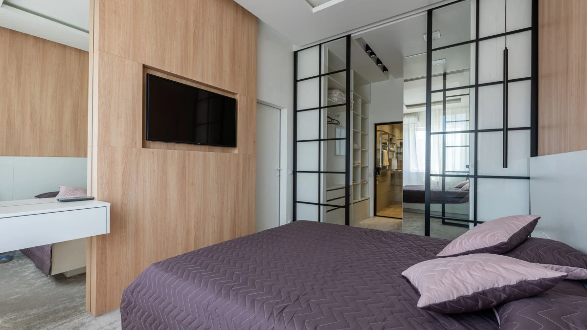 Moderne slaapkamer met eigentijds ontwerp en houten panelen en glazen elementen.