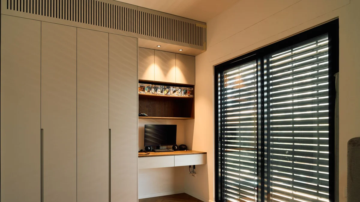 Een minimalistische thuiswerkplek met een strakke vormgeving en voldoende natuurlijke verlichting door grote jaloezieën.